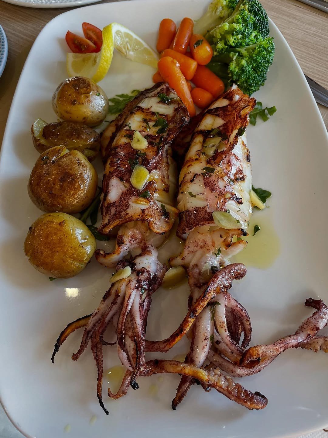Lulas grelhadas com batatas, cenoura, brócolos e limão